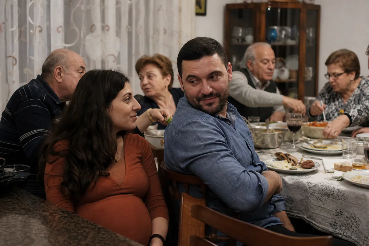 A crowded family dinner table, with a couple in the foreground catching each other's eye